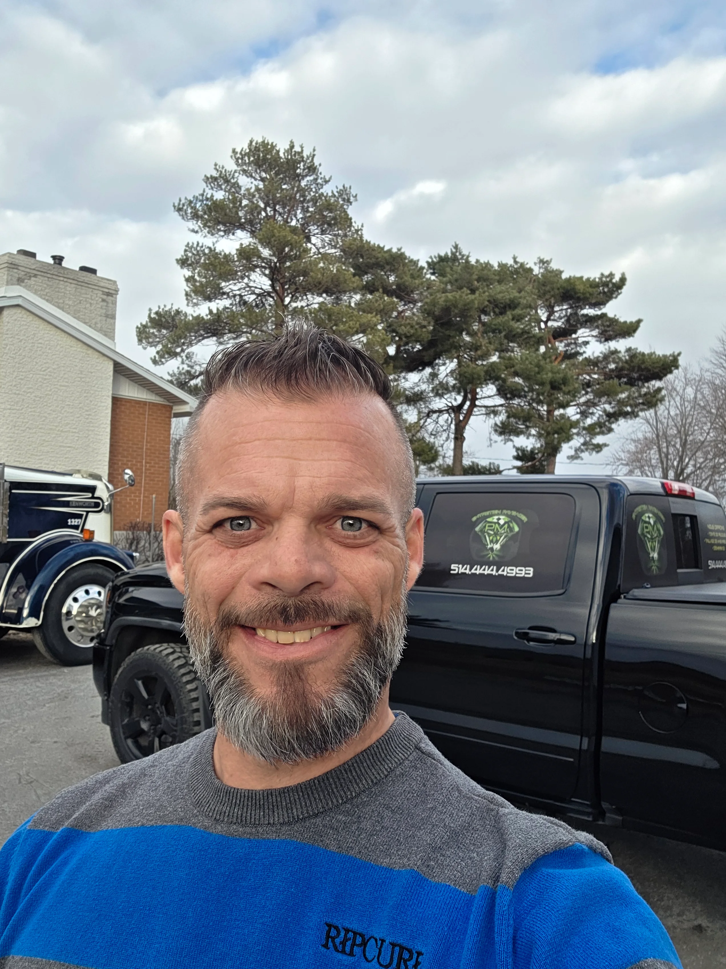 Portrait de Pascal Michon, fondateur d'Entretien Paysager PM, devant son camion de service